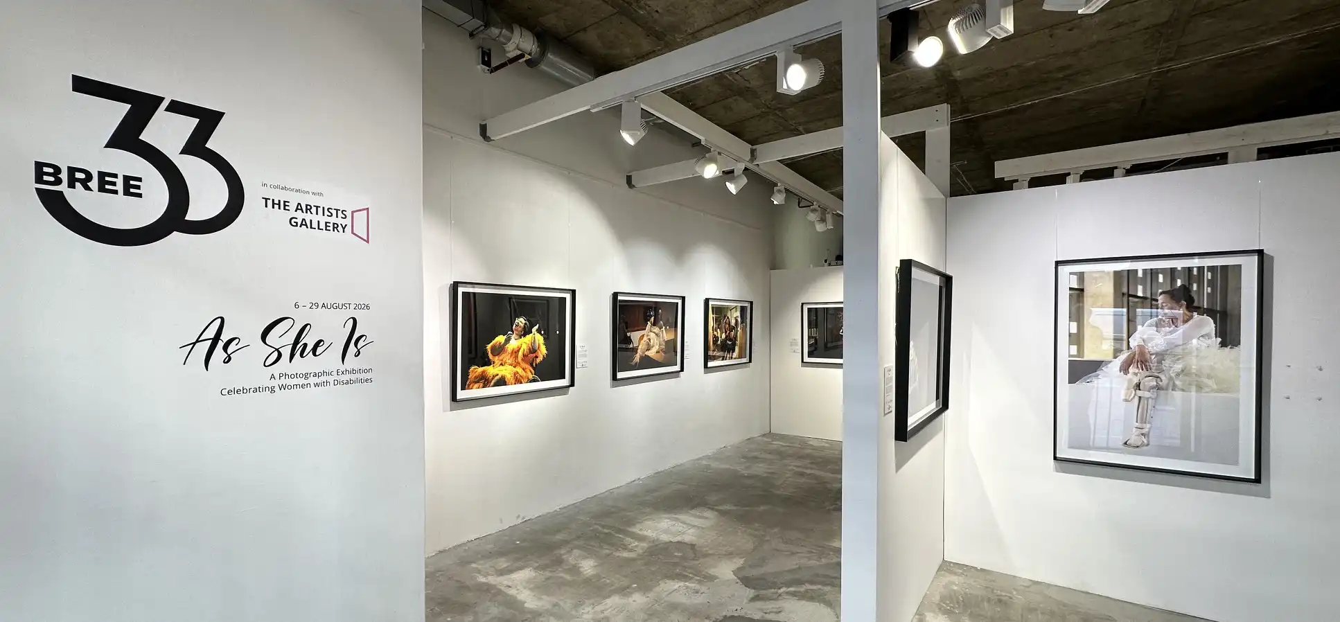 The As She Is title and photographic portraits installed across the white-walled galleries at 33BREE.